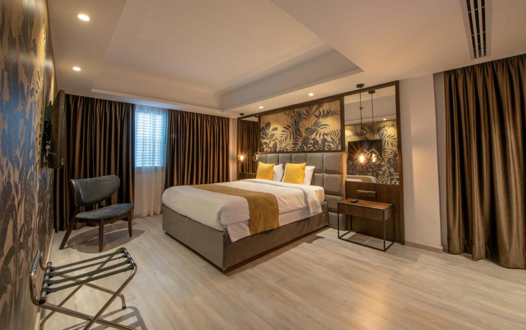 尼科西亚Almond Business Hotel的配有一张床和一把椅子的酒店客房