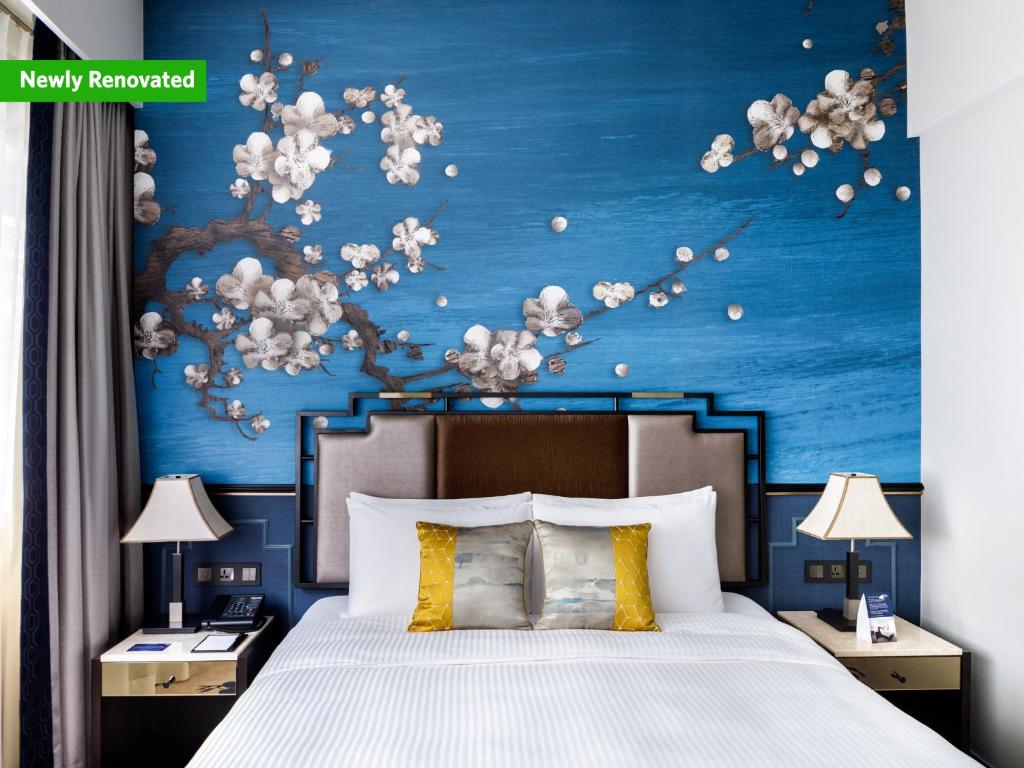 新加坡Copthorne King's Hotel Singapore on Havelock的一间卧室设有一张蓝色墙壁的大床