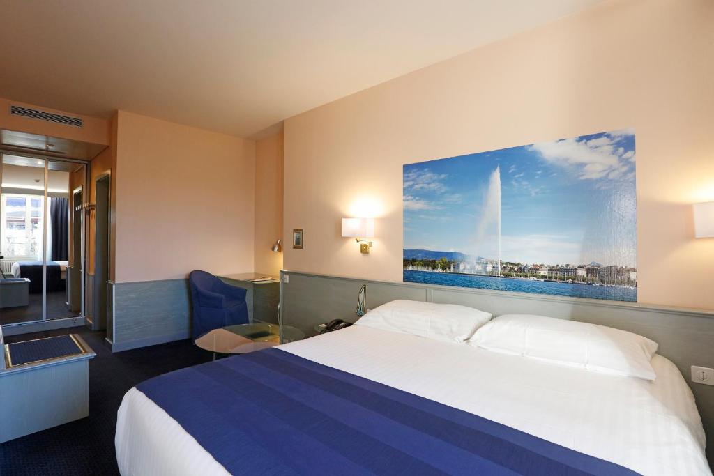 日内瓦蒙布里昂酒店的酒店客房设有一张床,墙上挂着一幅大画
