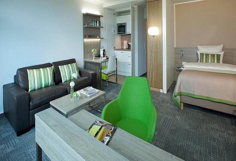 杜塞尔多夫Messe Residence Boardinghouse的一间带一张床的客厅和一间带沙发的房间