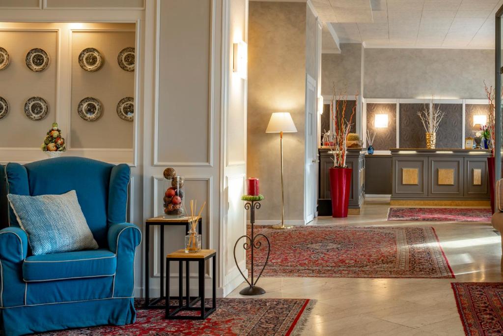 布雷西亚安巴夏托利酒店的客厅配有蓝色椅子和地毯