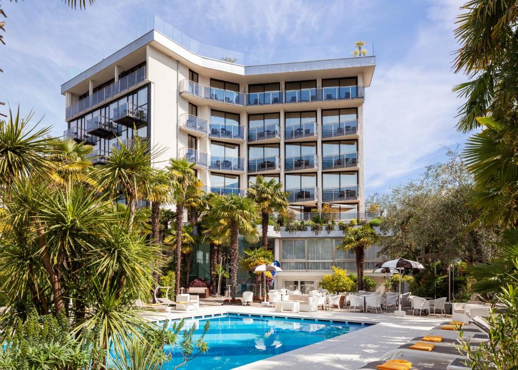 加尔达湖滨Garda Suite Hotel - TonelliHotels的大楼前设有游泳池的酒店
