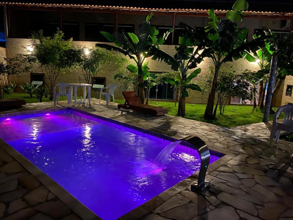 布希奥斯Recanto Praiana de Búzios的夜晚后院的紫色灯光泳池