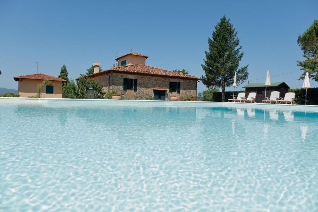 圣多纳托因弗伦萨诺Podere I Sorbi的一座大型游泳池,后面有一座房子