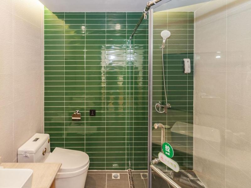 大连格林豪泰大连机场新区辛寨子智选酒店的绿色瓷砖浴室设有卫生间和淋浴。
