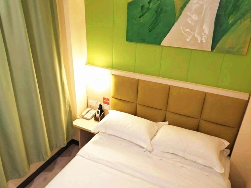 武汉贝壳武汉市武汉大学酒店的一间卧室配有一张白色的床和绿色的墙壁