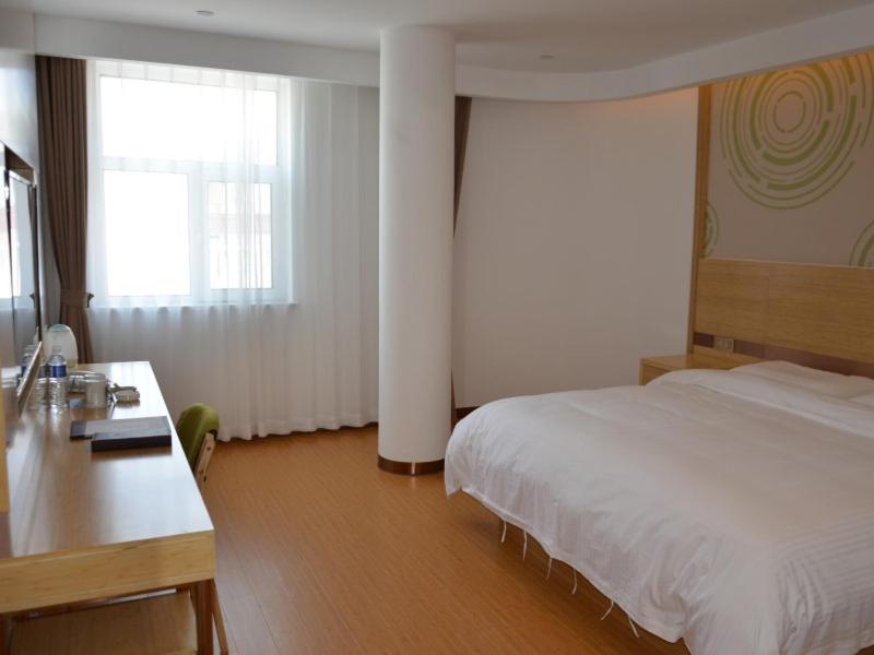 唐山格林豪泰唐山市路北区韩城镇利康医院智选酒店的卧室配有白色的床、书桌和窗户。