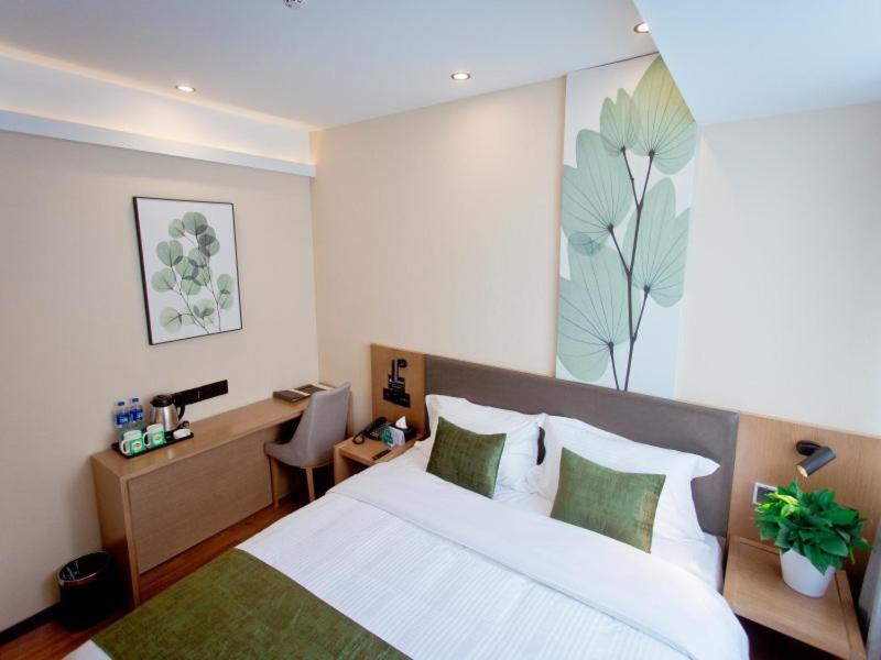阜阳格林豪泰阜阳市颍州区奎星路商务酒店的卧室配有一张白色大床和一张书桌