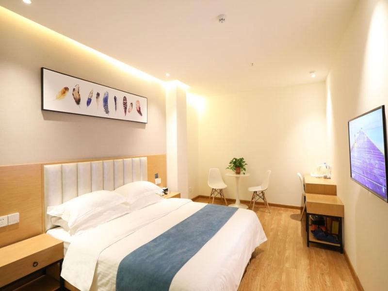 新郑贝壳郑州国际机场华夏大道酒店的一间卧室配有一张床、一张书桌和一台电视。
