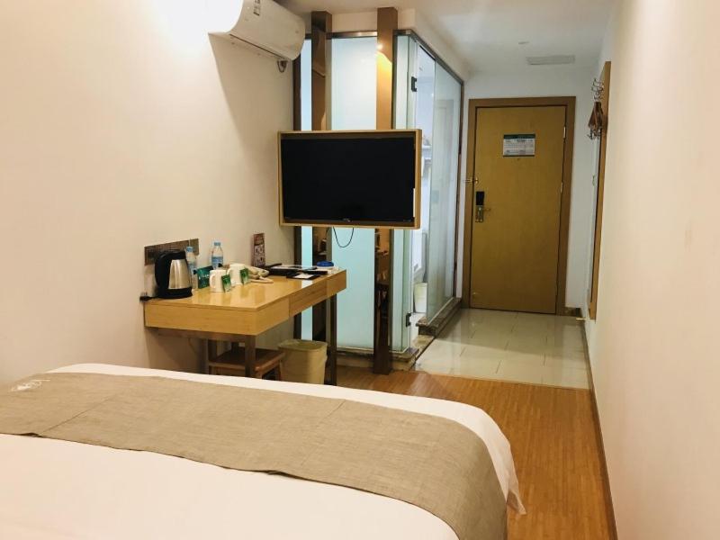 桂林格林豪泰桂林临桂区麓湖国际快捷酒店的一间卧室配有一张床和一张书桌及电视
