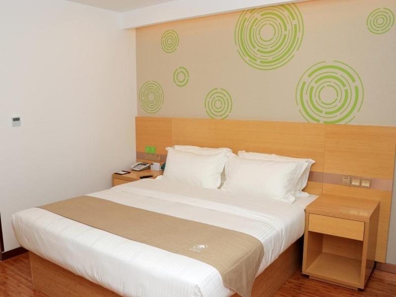 黄石格林豪泰黄石市花湖开发区大泉路商务酒店的一间卧室配有一张带白色床单的大床