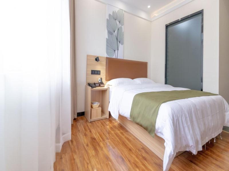 安顺格林豪泰黄果树瀑布景区智选酒店的一间卧室设有一张大床和一个大窗户