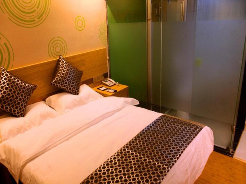 南京格林豪泰南京市省人民医院智选酒店的一间卧室设有一张床和玻璃墙