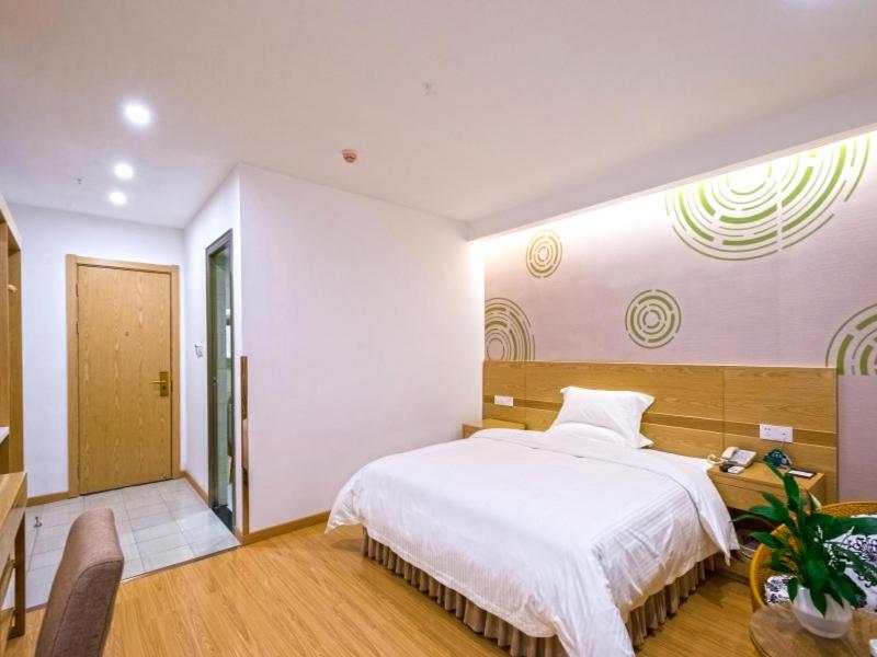 安顺格林豪泰安顺西航路商务酒店的卧室配有一张白色大床和一张书桌