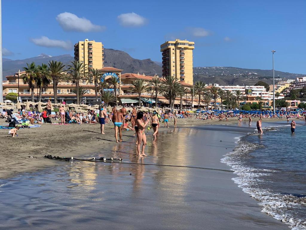 阿罗纳Apartamento en Playa Las Vistas - Torres del Sol的一群人在海滩上散步