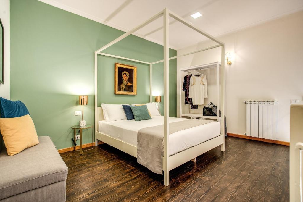那不勒斯Casa Hosteno的一间卧室配有天蓬床和沙发