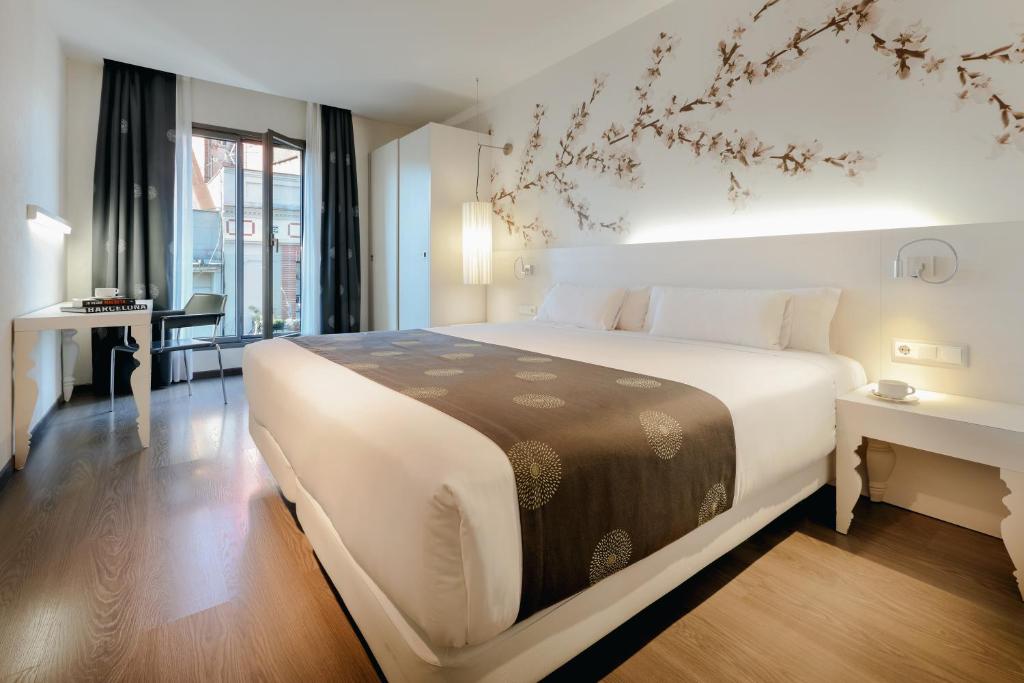 巴塞罗那RAMBLAS HOTEL powered by Vincci Hoteles的卧室配有一张白色大床和一张书桌