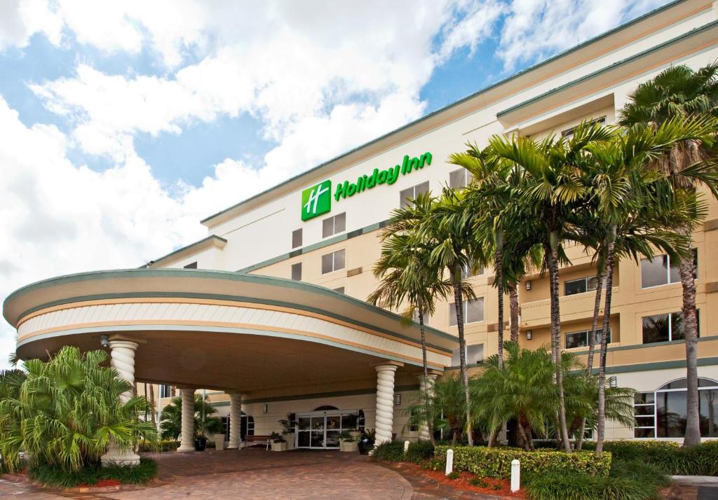 好莱坞劳德代尔堡机场假日酒店的一座医院大楼前面有棕榈树
