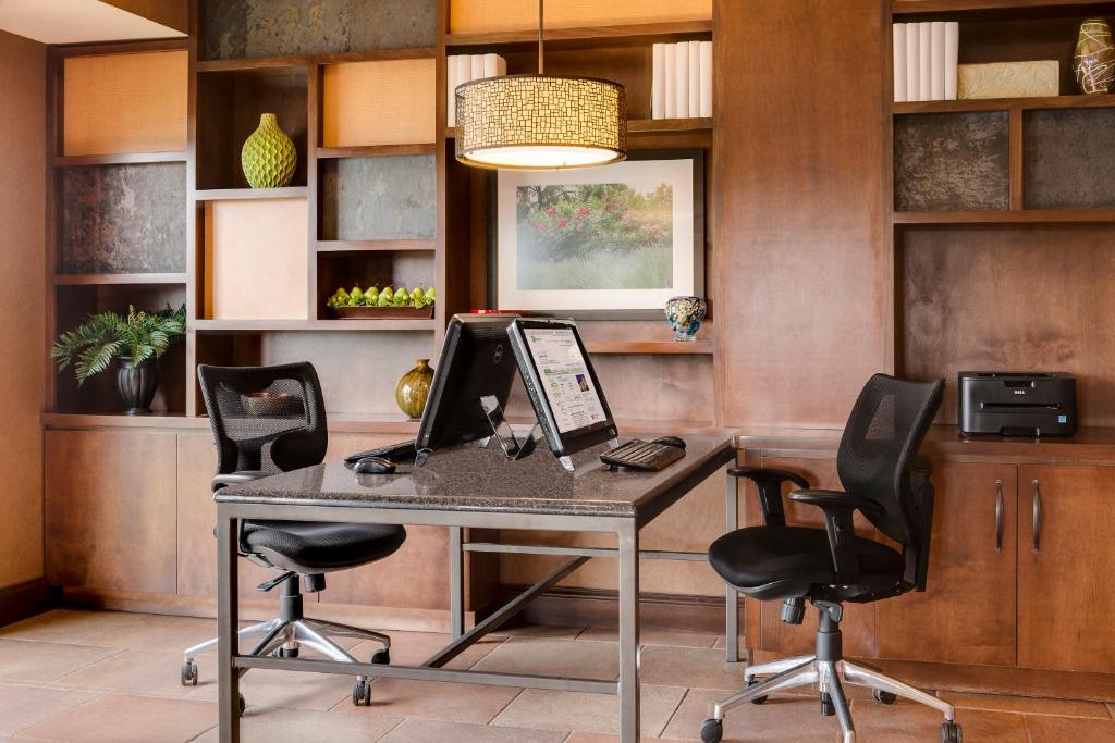 康瑟尔布拉夫斯康瑟尔布拉夫斯智选假日酒店及套房的办公室配有一张桌子、一台笔记本电脑和两把椅子