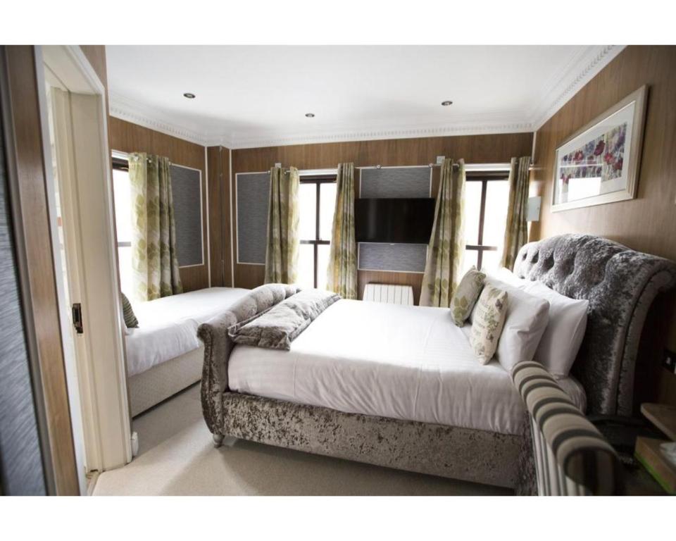 伦敦Cheshire Hotel Central London的一间带两张床和一张沙发的客厅