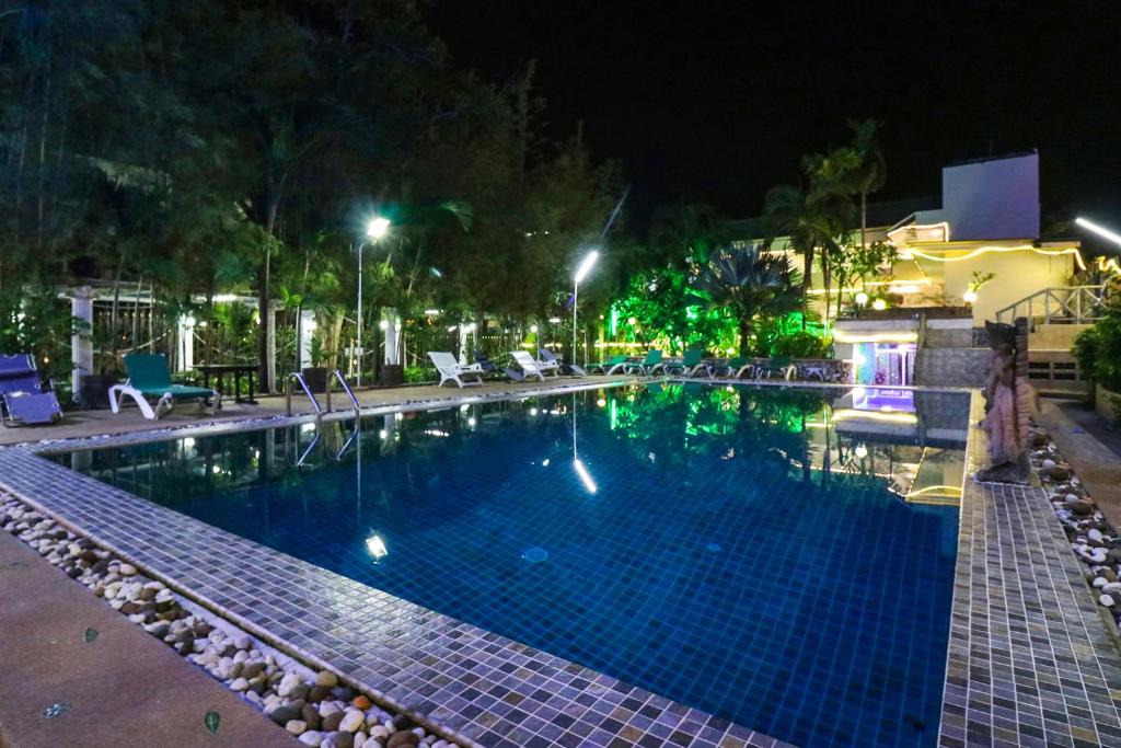 芭堤雅市中心Natural Beach Hotel Pattaya的夜间游泳池,灯光照亮