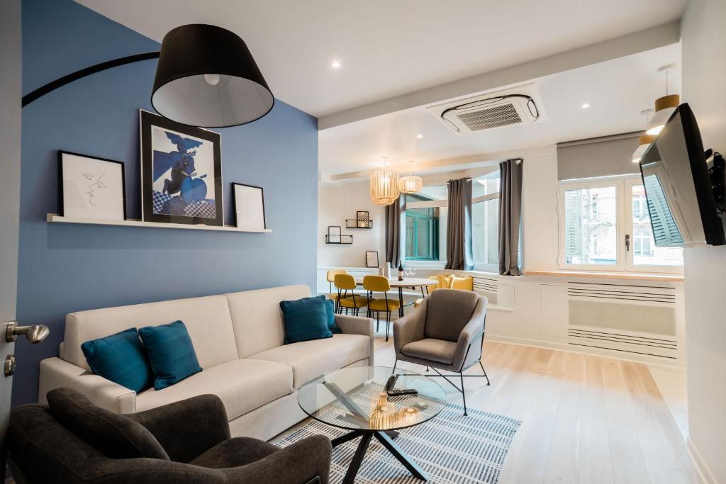 巴黎SUITE APOLLINAIRE : au cœur de la Rive Gauche, neuf, design, 2/4 personnes的客厅设有白色沙发和蓝色的墙壁。
