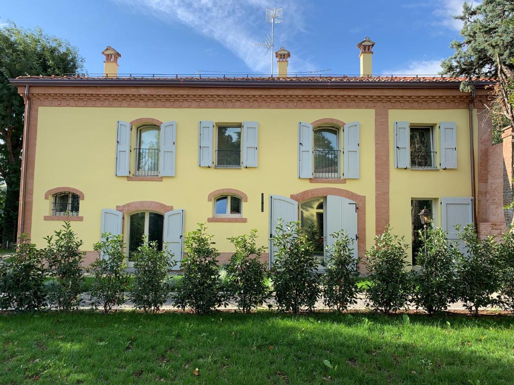 博洛尼亚Antico Podere San Luca的黄色的房子,有窗户和院子