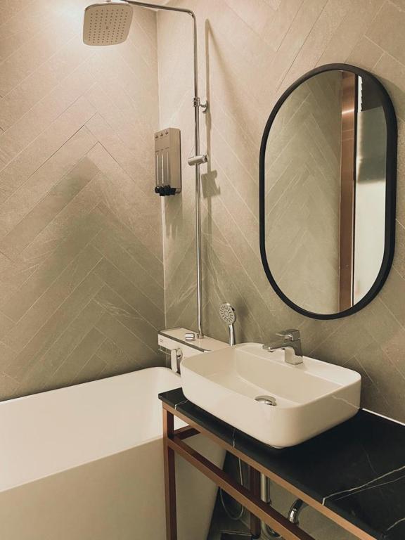 首尔Hotel the Castle Banyi的一间带水槽和镜子的浴室