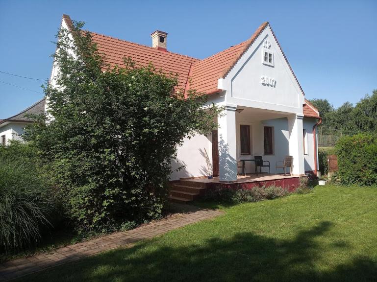 HerendPark Vendégház的一间白色的小房子,有红色的屋顶