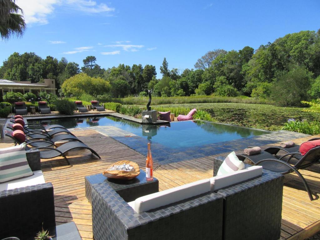 克拉格斯莲花池乡村旅舍的一个带躺椅的游泳池和一个带池塘的庭院