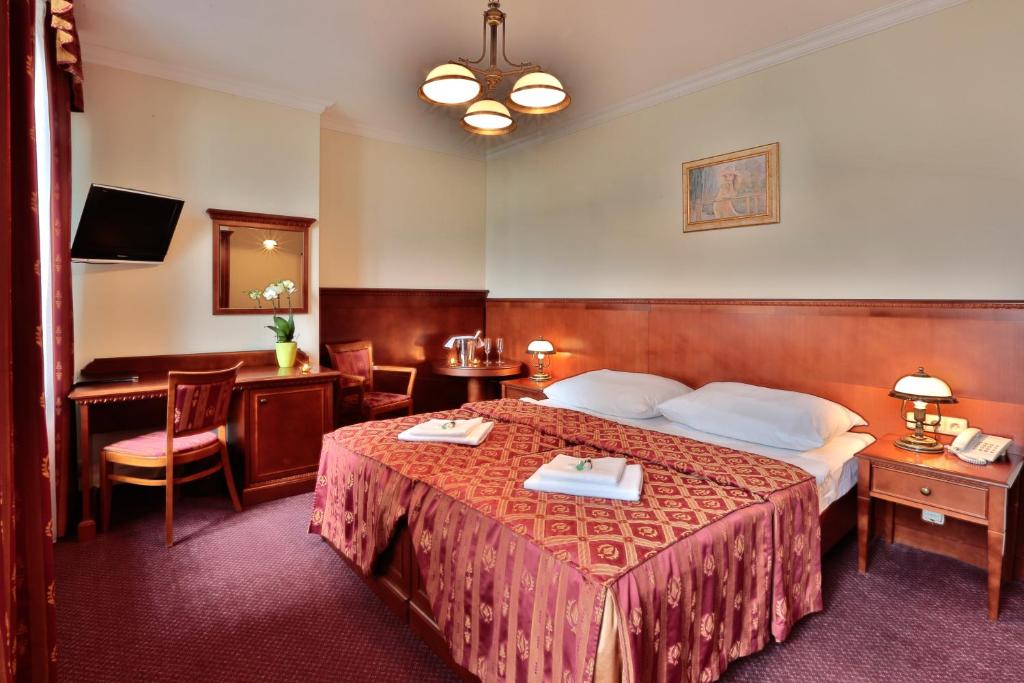 布拉格普拉哈阿卡达酒店的酒店客房设有一张大床和一张书桌。
