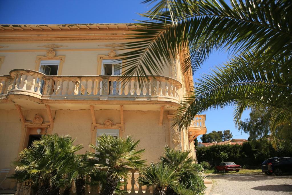 圣拉斐尔太阳酒店的带阳台的建筑,前面有棕榈树