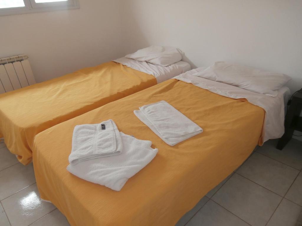 布兰卡港Apart 12 de Octubre 1028的两张床并在一起,配有毛巾