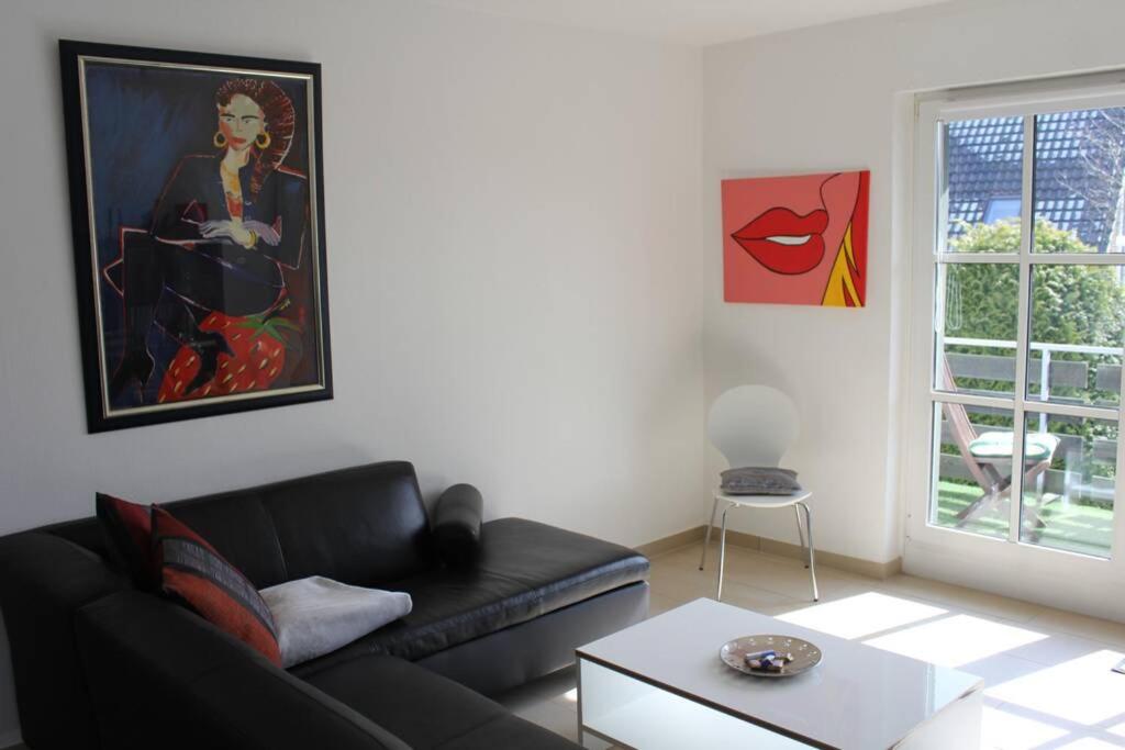 勒斯拉特Große Wohnung 20 km von Köln bis zu 14 Personen的客厅配有黑色沙发和绘画作品