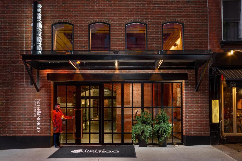 纽约Hotel Indigo Lower East Side New York的站在建筑物门口的人