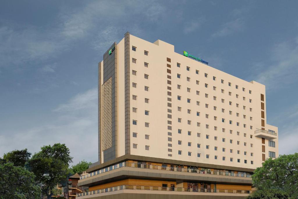 古尔冈Holiday Inn Express Gurugram Sector 50, an IHG Hotel的前面有树木的白色大建筑