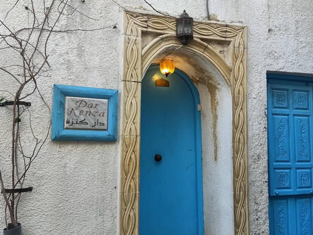 突尼斯Dar kenza Tunis的建筑物一侧的蓝色门和标志