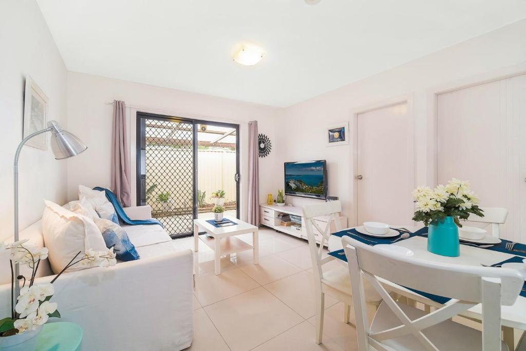 悉尼3 Bedrooms Holiday Home Near Sydney Airport的客厅配有沙发和桌子