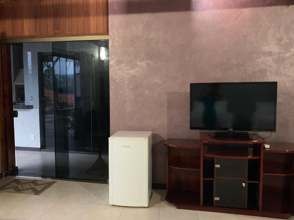 卡皮托利乌Chalés da Zelma的客厅配有平面电视和垃圾桶
