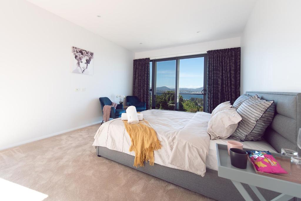 霍巴特Nature & Relax House, Panoramic sea view, Free parking40的一间卧室设有一张床和一个大窗户