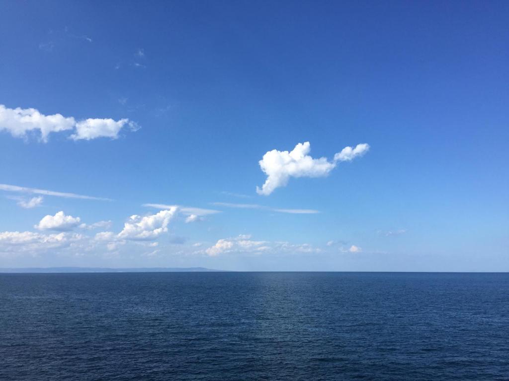 索佐波尔Deep Blue Guest House的蓝色天空和云层的大水体