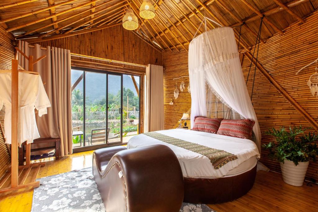 宁平Trang An Lamia Bungalow的一间卧室设有天蓬床和窗户。