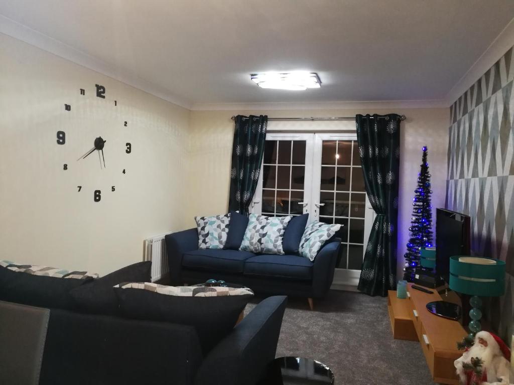 东基尔布赖德Stewartfield Gardens Apartment的客厅配有蓝色的沙发和圣诞树