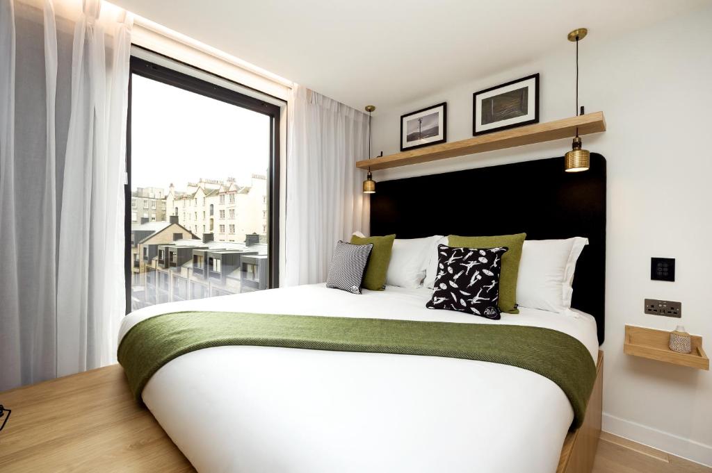 爱丁堡Wilde Aparthotels Edinburgh Grassmarket的一间卧室设有一张大床和大窗户