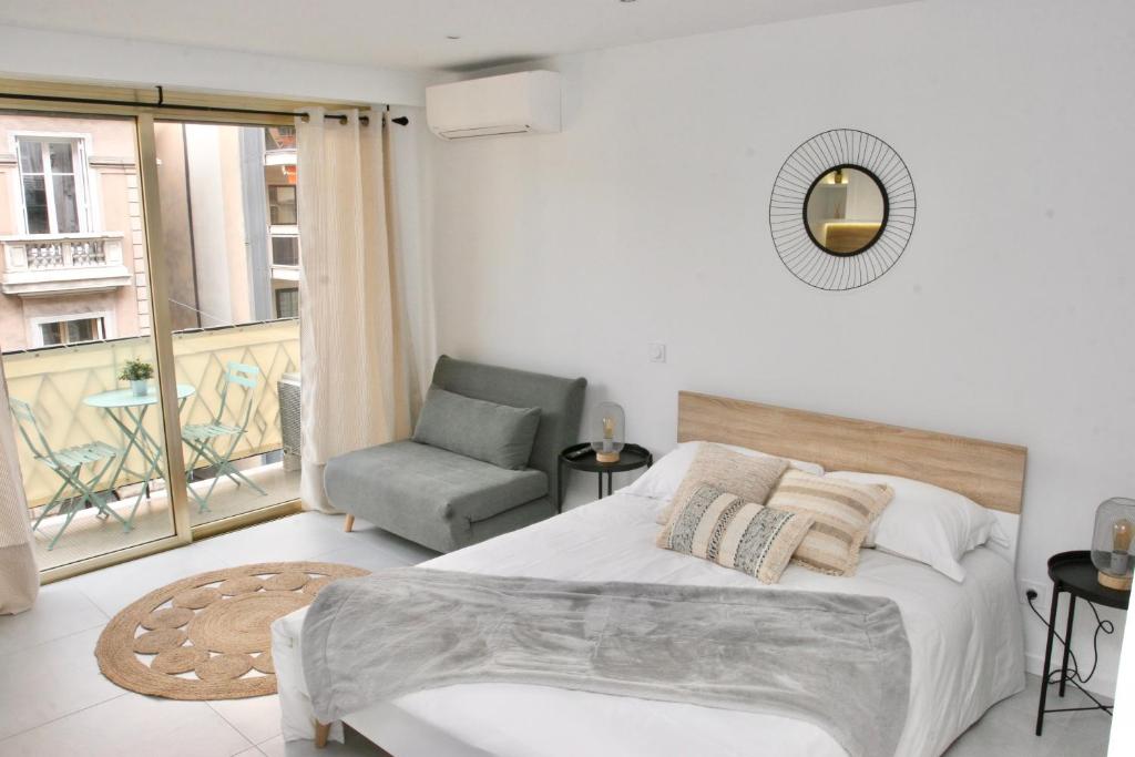 尼斯Le Melsono Carré d'Or的卧室配有床、椅子和窗户。