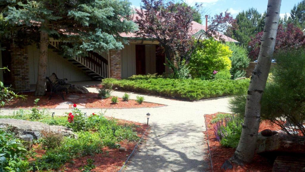 布鲁姆菲尔德Hilltop Inn Broomfield Denver的一座带花园和走道的房子