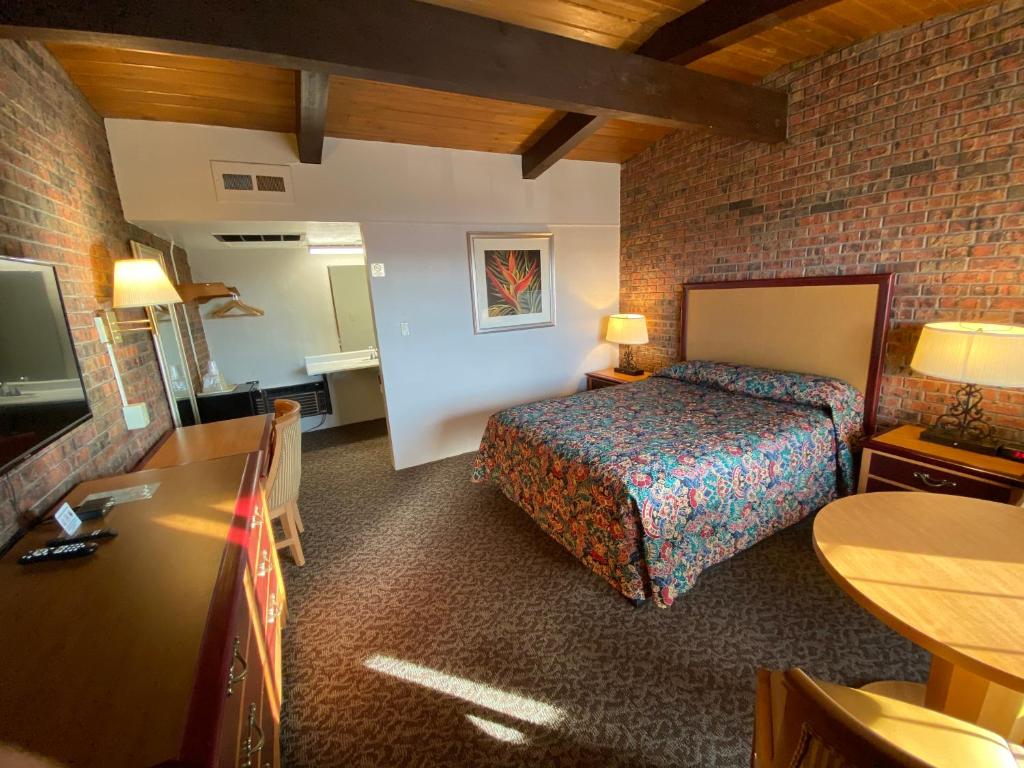 阿拉莫萨Dunes Inn Alamosa的酒店客房,配有床和电视