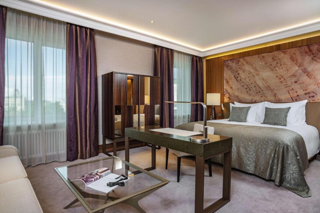 里加里加凯宾斯基大酒店的配有一张床和一张书桌的酒店客房