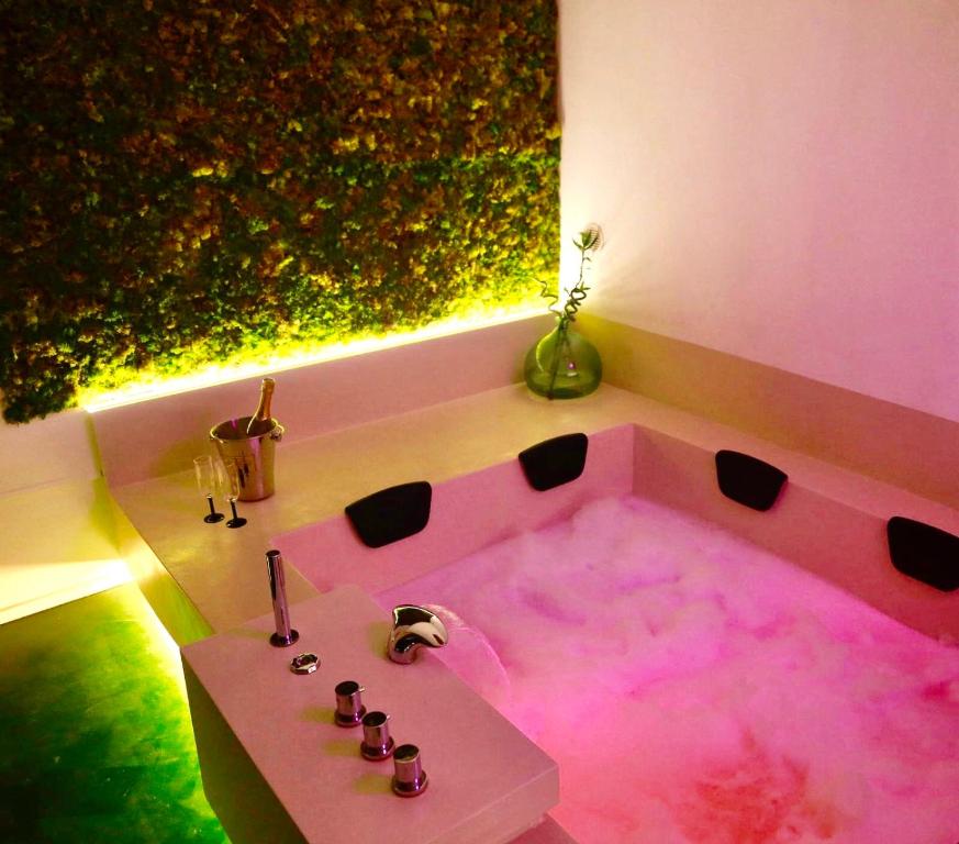 阿尔塔穆拉Suite61的客房内的粉红色浴缸配有桌子