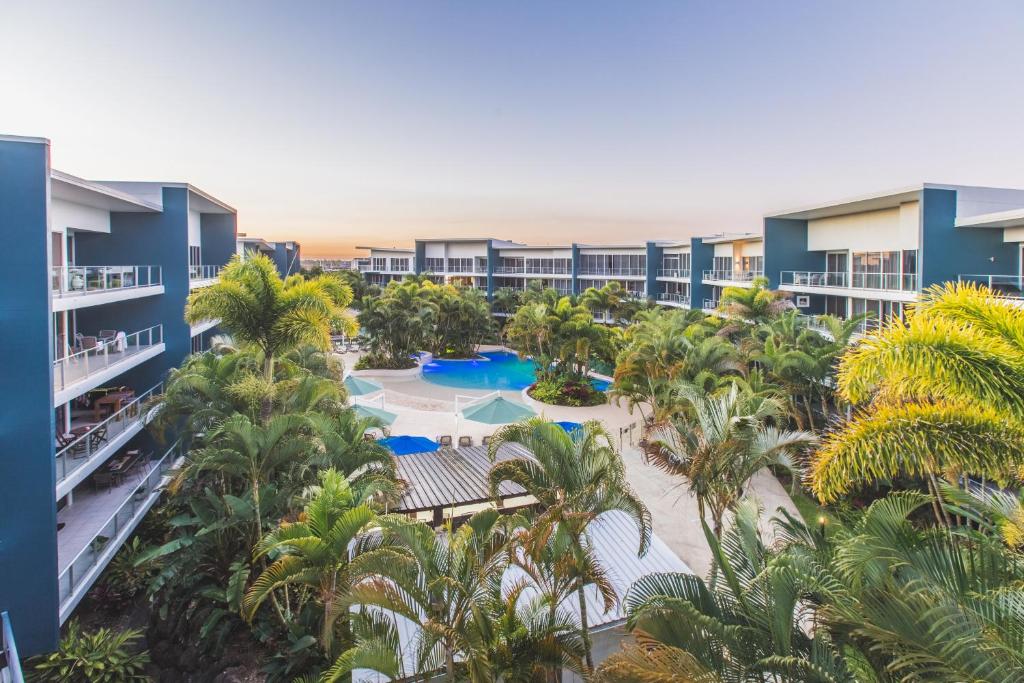 黄金海岸阿苏拉绿色度假酒店的享有棕榈树和游泳池度假村的空中景致